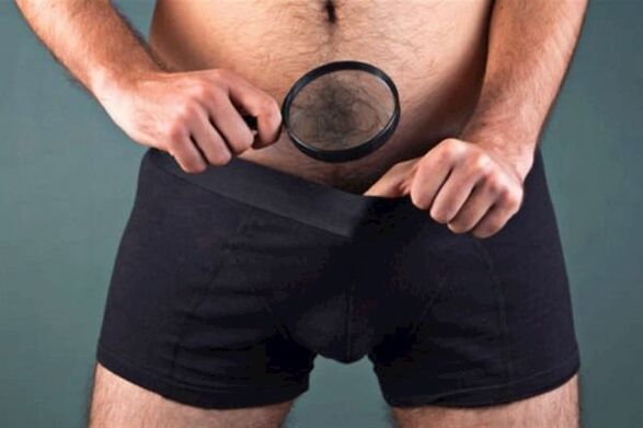 isang lalaking may magnifying glass ang sumusuri sa kanyang ari at gustong kumapal